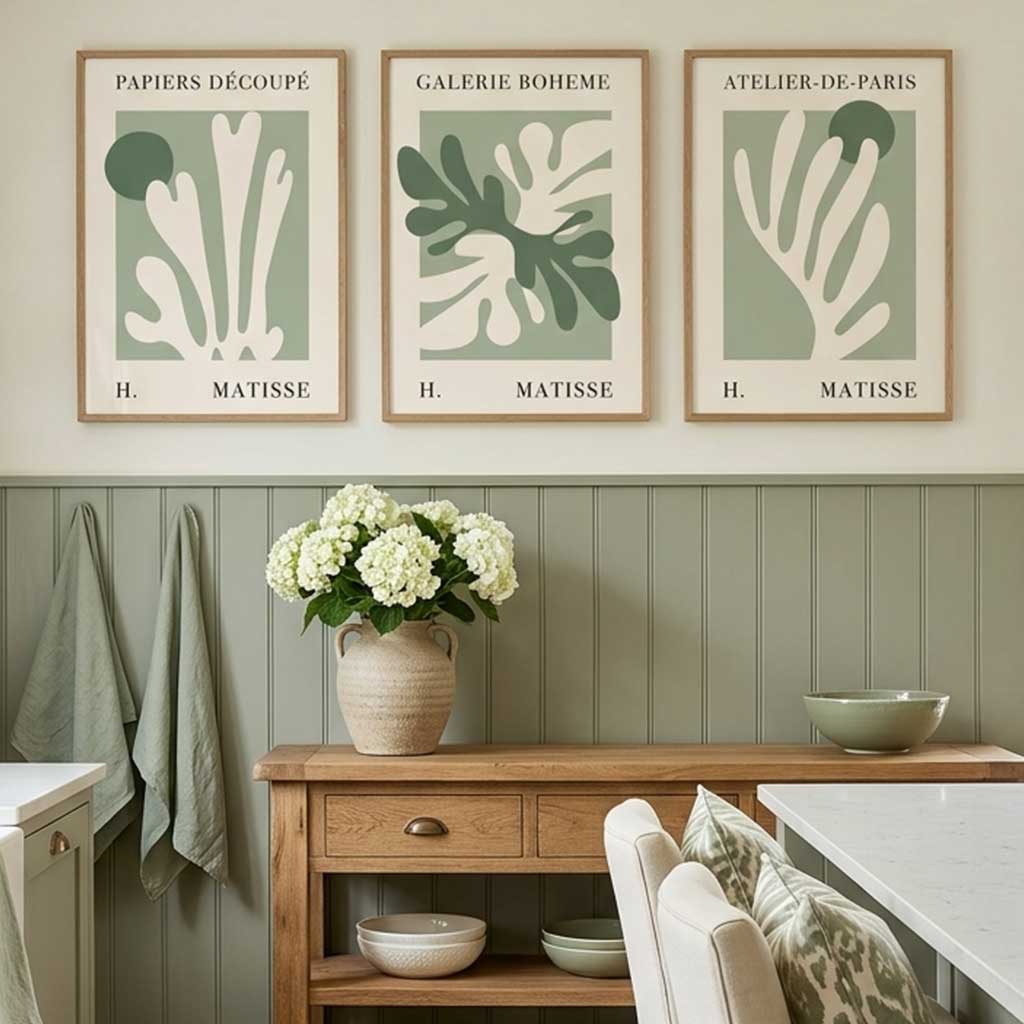 Three framed Matisse art prints with abstract coral-like designs in sage green and cream hang on a beige wall above a wooden console table in a styled dining/kitchen setting.