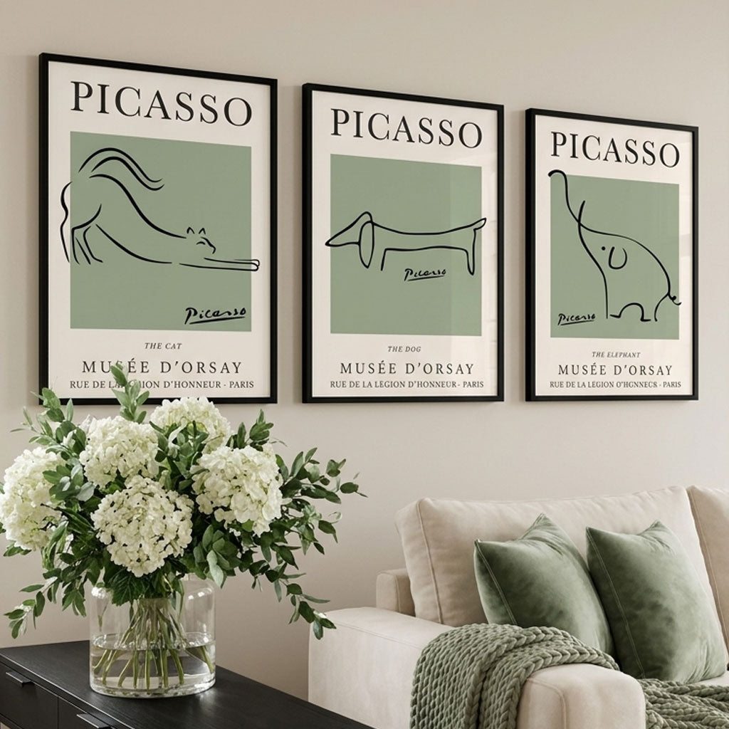 A Set of 3 minimal picasso animal prints in sage green with black frames in a neutral luxury living room